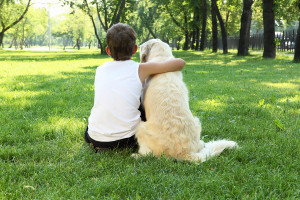 Tennager boy in the park with a dog